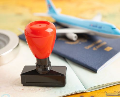 Stempel, Kompass. Flugzeug, Pass nebeneinander auf einer Urkunde